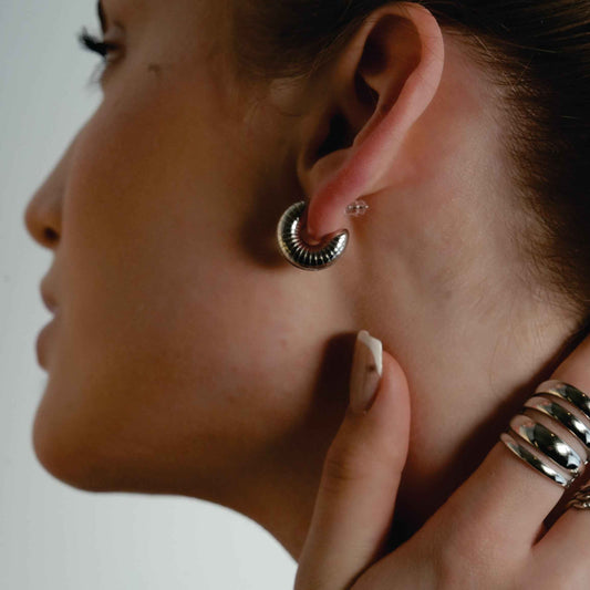 KOTOHIRA: Hollow Chunky-Look Textured Surface Tube Hoop Earrings in Silver Toned White Gold